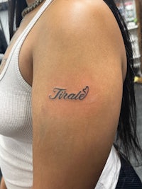 a woman with a tattoo on her arm with the word triad