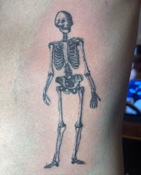 a tattoo of a skeleton on a person's back